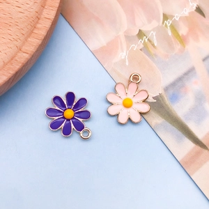 Macro detail of daisy flower enamel charms in purple and pink for DIY jewelry making