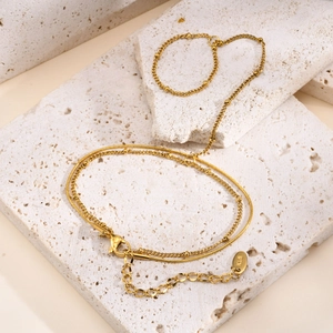 Close-up of 18K gold-plated double-layer snake and bead chains with lobster clasp