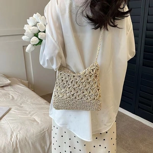 Bohemian woven straw crossbody bag featuring hollow floral pattern and slim shoulder strap