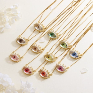 Detail of colorful evil eye sun pendants with shimmering cubic zirconia in gold plating