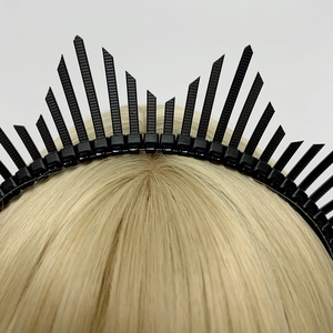 Close-up of black spiked crown headband accessory styled on blonde hair model