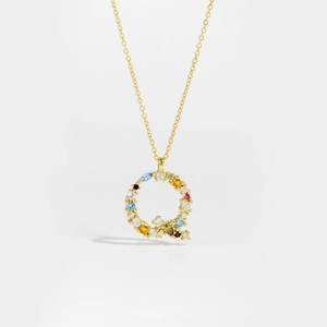 Close-up of golden S925 silver letter Q pendant with colorful zircon and diamonds