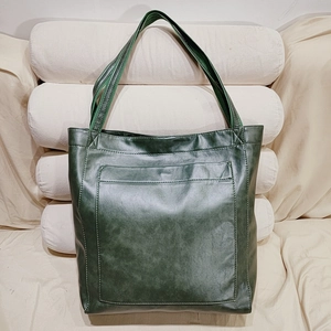 Détail du sac cabas vert en cuir ciré vintage avec poche avant et longues anses
