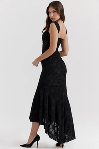 Detail view of black lace dress with intricate floral jacquard and fishtail hemline