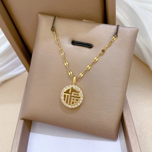 Gold titanium necklace with Fu character pendant and crystal pavé in a gift box