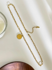 Detail of 18K gold paperclip necklace with engraved round pendant and lobster clasp