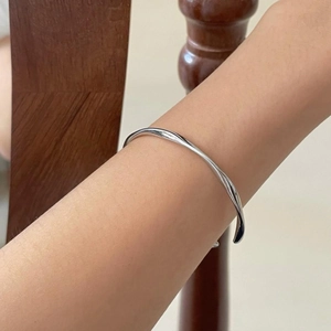 Minimalist S925 sterling silver Mobius twist cuff bracelet worn on arm for scale