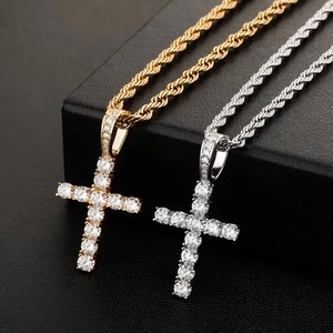 Macro view of gold and silver cross pendants with shimmering crystals on twisted rope chains