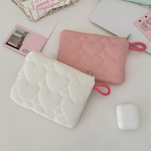 Detailed view of quilted heart pattern pouches in pink and white with matching zippers