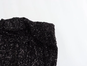 Detail of black sequins fabric and invisible zipper on the elegant dress shoulder