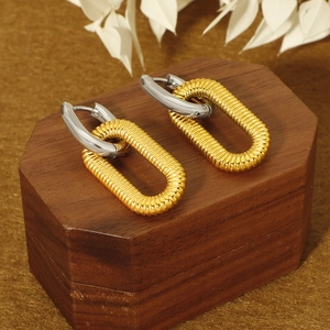 Detailed close-up of two-tone double hoop earrings with textured gold and silver finish