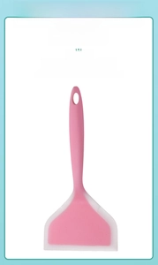 Vue détaillée d'une spatule en silicone rose et blanc avec trou de suspension pratique