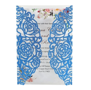 Detailed laser-cut blue glitter wedding invitation with elegant floral lace patterns