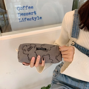 Close-up of a grey corduroy pencil case with a cute bear pattern held in hand