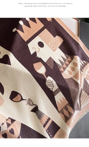 Detail of cashmere-like scarf with cartoon poker king pattern in beige and brown tones