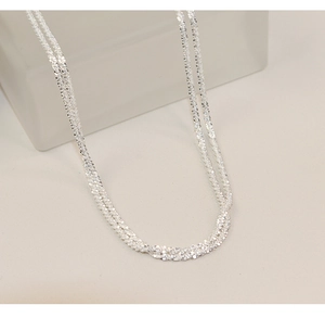 Close-up of shimmering 925 sterling silver multi-strand necklace with fine metallic texture