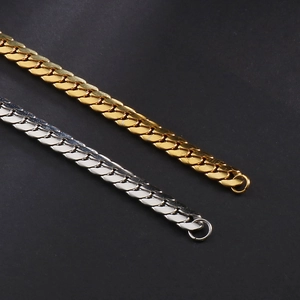 Macro detail of flat gold and silver Cuban chain links with polished metal texture