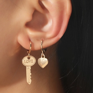 Close-up of gold geometric ear cuff set with LOVE engraved key and heart charms