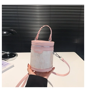 Detail of pink and white cylindrical bucket bag with embossed texture and metal zipper