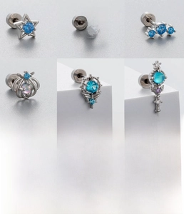 Gros plan de clous d'oreilles en acier titane avec zircon bleu et motifs célestes