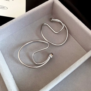 Macro detail of silver geometric double-layered ear cuff in a grey velvet jewelry box