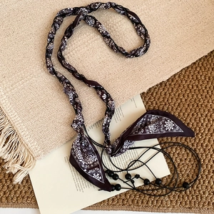 Détail d'une ceinture en soie vintage avec motifs mandala ethniques et perles en bois