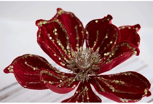 Close-up of red velvet artificial flower with gold glitter edges for festive decor