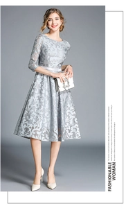Detail of silver lace embroidery on an elegant midi dress with a white satin belt
