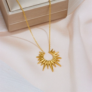 Elegant gold sunburst star pendant necklace on beige fabric with a luxury jewelry box
