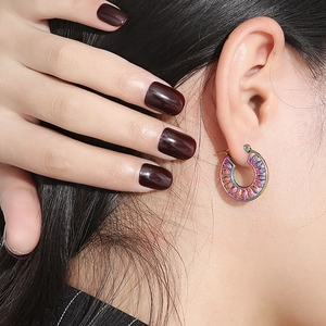 Detail of colorful iridescent hollow leaf earrings worn on a model in a close-up view