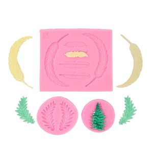 Détail macro de trois moules en silicone rose motif feuilles et plumes avec modèles