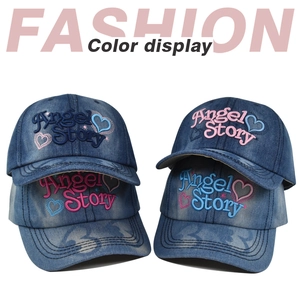 Dettaglio del ricamo Angel Story su cappellini da baseball in denim lavato blu scuro