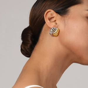Close-up of twisted knot earrings in gold and silver finish worn by a model