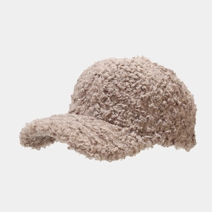 Detail of light brown sherpa baseball cap showing soft curly faux fur texture and curved brim