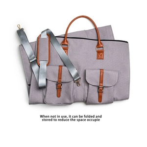 Housse de vêtement pliable en toile grise avec détails en cuir brun et bandoulière