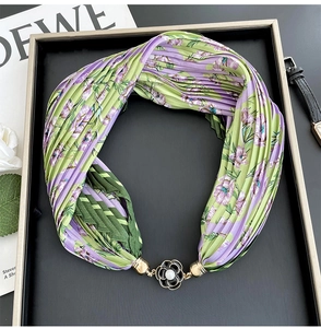 Detailed close-up of a floral pleated silk scarf with a pearl flower magnetic buckle