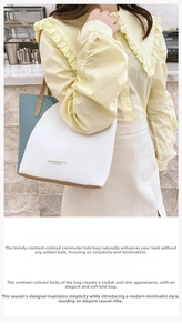 Detail of color-block tote bag featuring leather handles and printed fashion text
