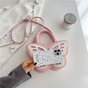 Detailed view of pink butterfly handbag with glitter accents and adjustable shoulder strap