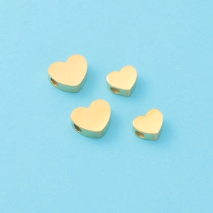Vue détaillée de quatre perles en forme de cœur en acier inoxydable doré pour bijoux DIY