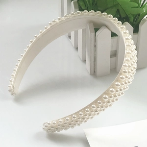 Detailed macro shot of white faux pearl headband with dense pearls and soft fabric lining