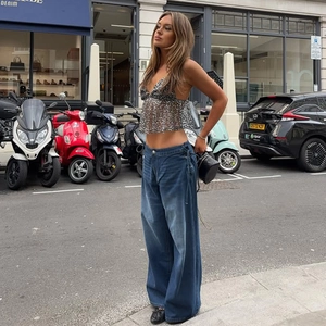 Streetstyle-Aufnahme eines silbernen Pailletten-Crop-Tops mit blauer Jeans für Damen