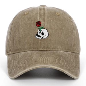 Close-up of skull and rose embroidery on khaki distressed cotton baseball cap