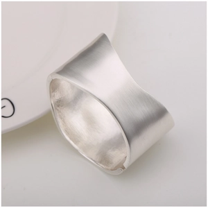Macro detail of the matte brushed silver finish on this wide open-cuff geometric bracelet