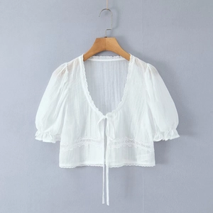 Détail de chemisier blanc à manches bouffantes avec dentelle et lacets à l'avant