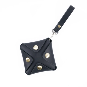 Mini black genuine leather coin purse with gold snaps and detachable strap on white background
