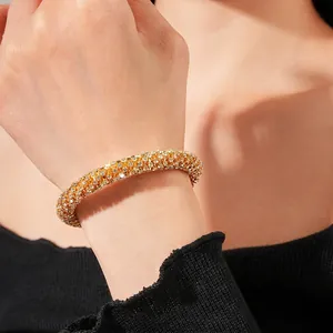 Sparkling crystal circular open bangle in gold finish worn on a female wrist