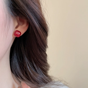 Close-up of a vintage red square stud earring on a model with elegant resin finish