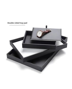 Detail view of stackable black jewelry trays with double-sided mat for watches and rings