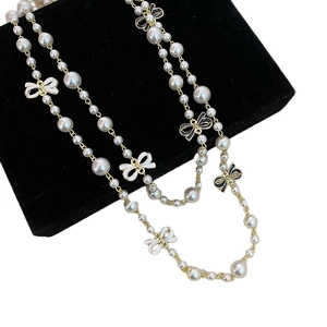 Elegant bow pearl necklace with black and white enamel detail in a jewelry box