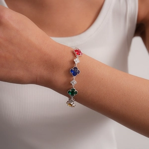 Vue détaillée d'un bracelet trèfle en argent orné de pierres colorées sur un mannequin